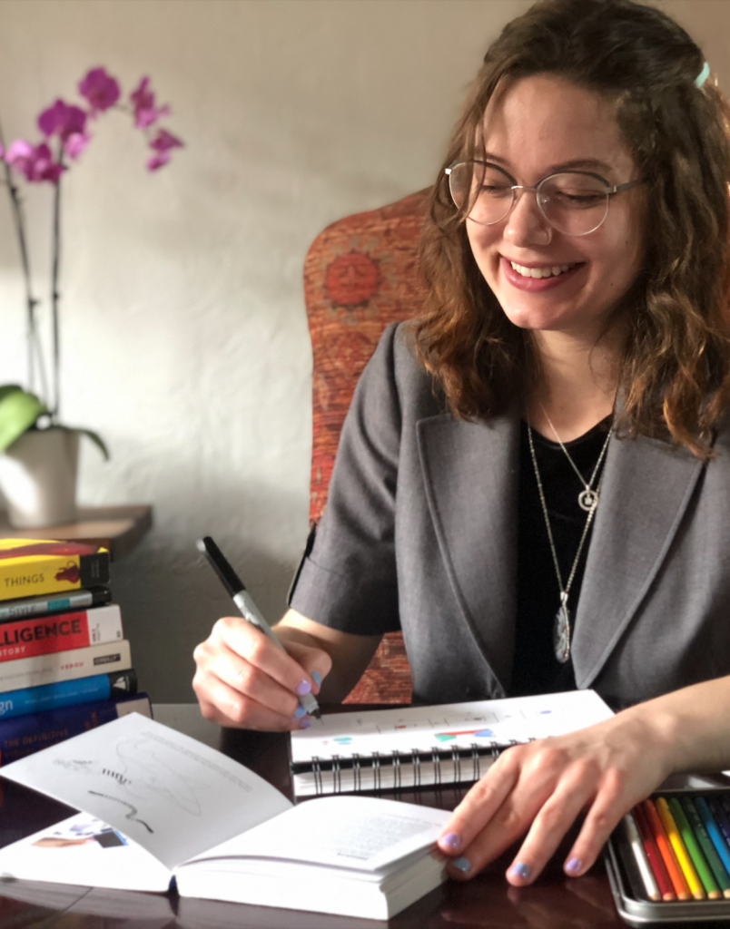 Kathryn wearing gray blazer, reading a book